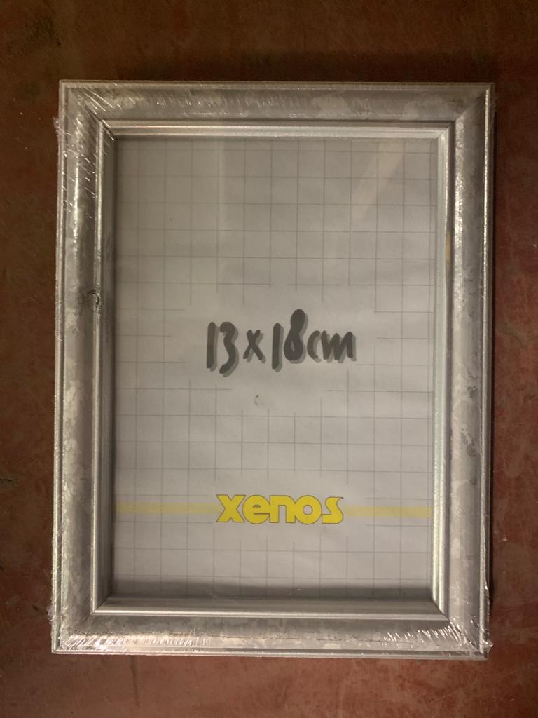 Eighteen Xenos silvered-finish photo frames, 13 cm x 18 cm, all brand new and still wrapped.