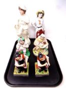A tray containing a pair of Staffordshire figures of a seated man together with four further