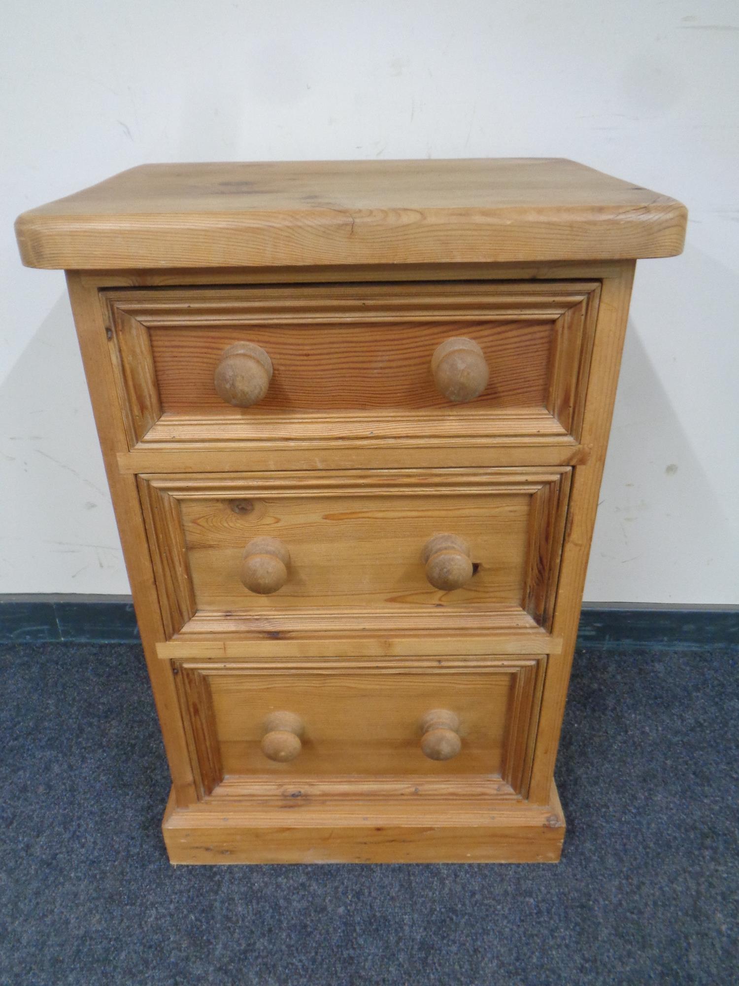 A pine three drawer chest together with a similar bedside chest