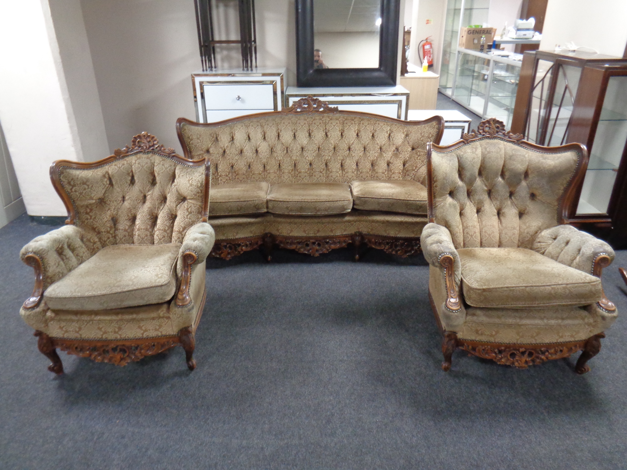 A three-piece lounge suite with carved beech frame,