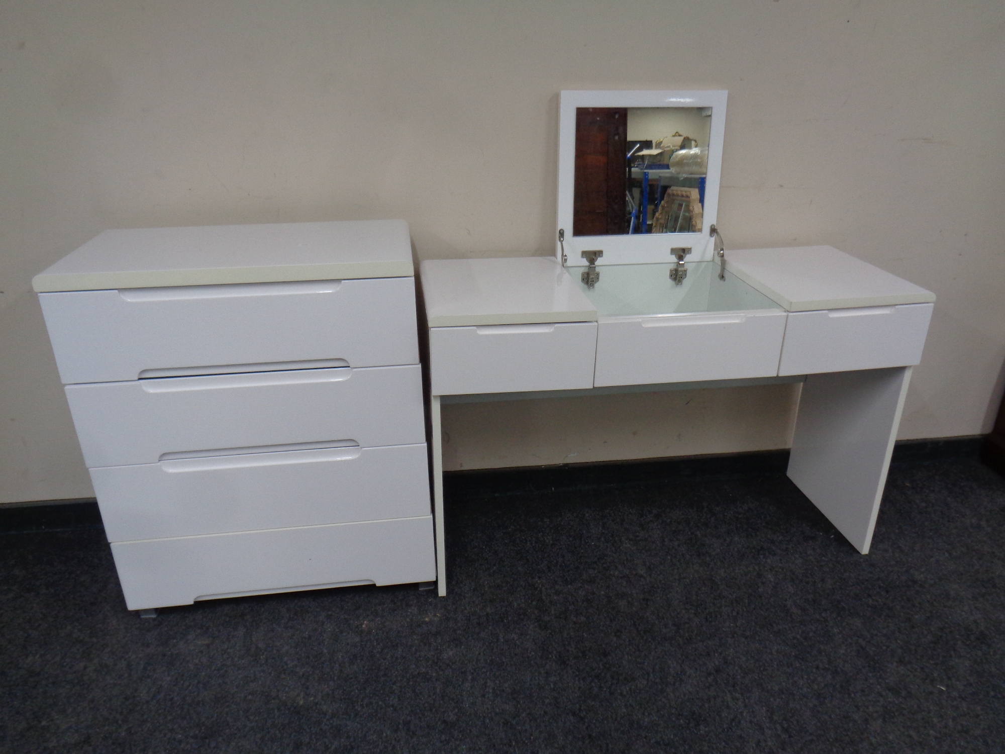 A contemporary white high gloss three drawer dressing table with matching four drawer chest