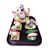 A tray containing a pair of Staffordshire figures of a seated lady together with three further