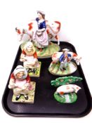 A tray containing a pair of Staffordshire figures of a seated lady together with three further