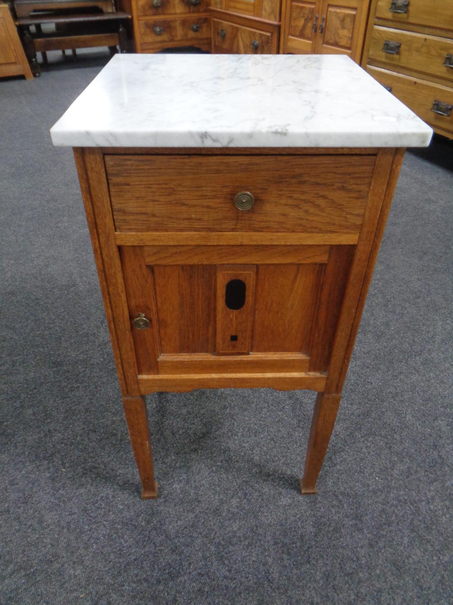 An Edwardian inlaid oak marble topped pot cupboard