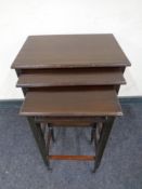 A reproduction mahogany nest of three tables