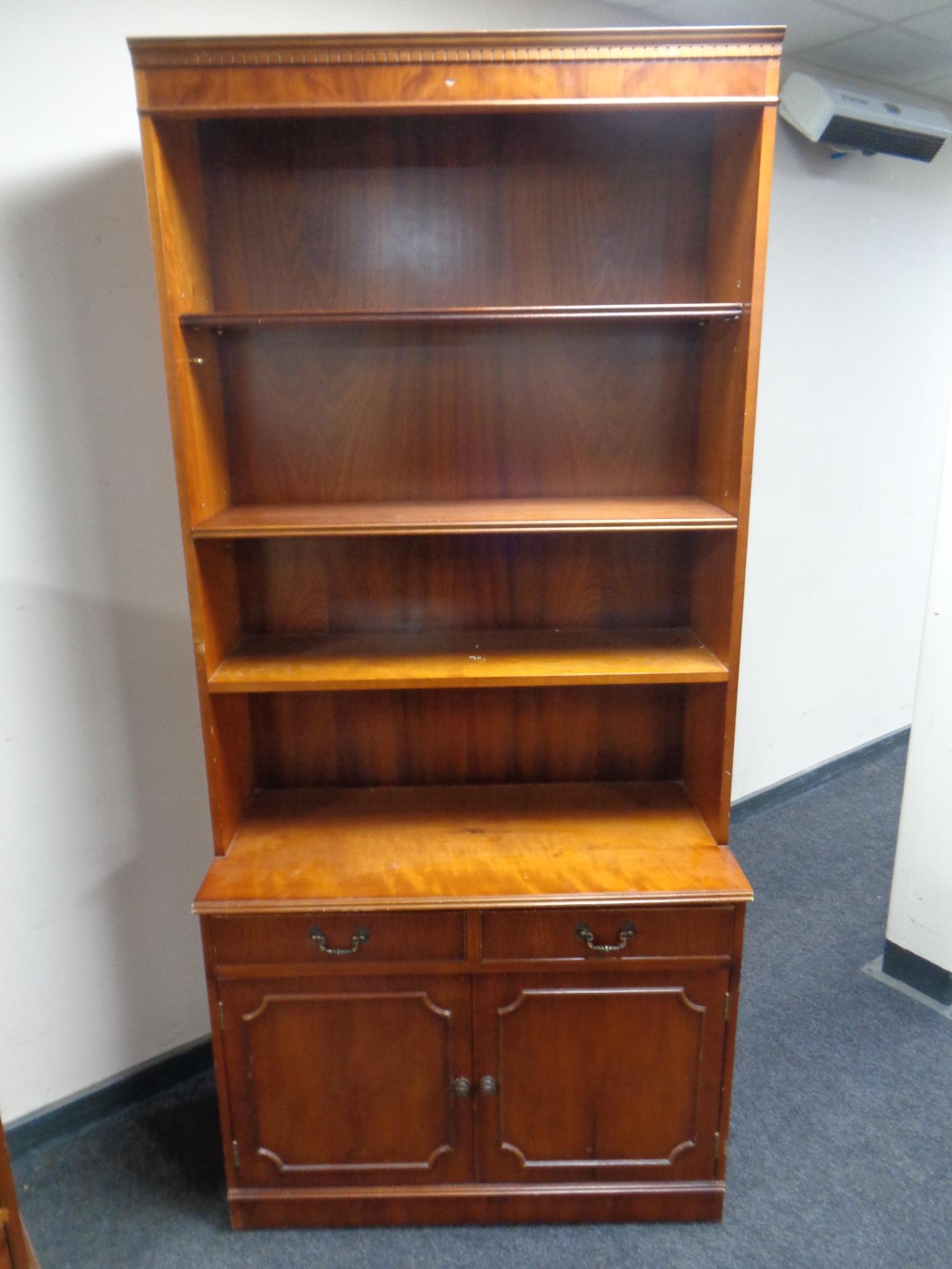 A reproduction yew wood open bookcase
