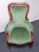 A Victorian carved mahogany armchair in green upholstery
