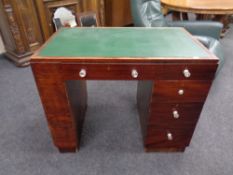 A 20th century stained single pedestal desk fitted five drawers with glass handles and a leather
