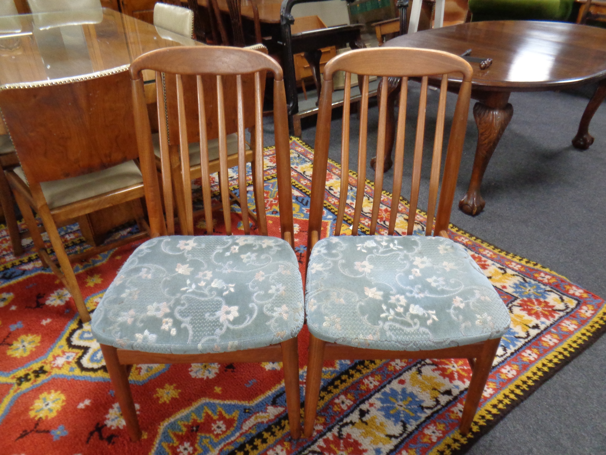 A pair of 20th century teak rail back dining chairs.