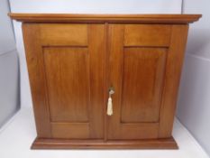 A stained pine two door cabinet with fitted interior