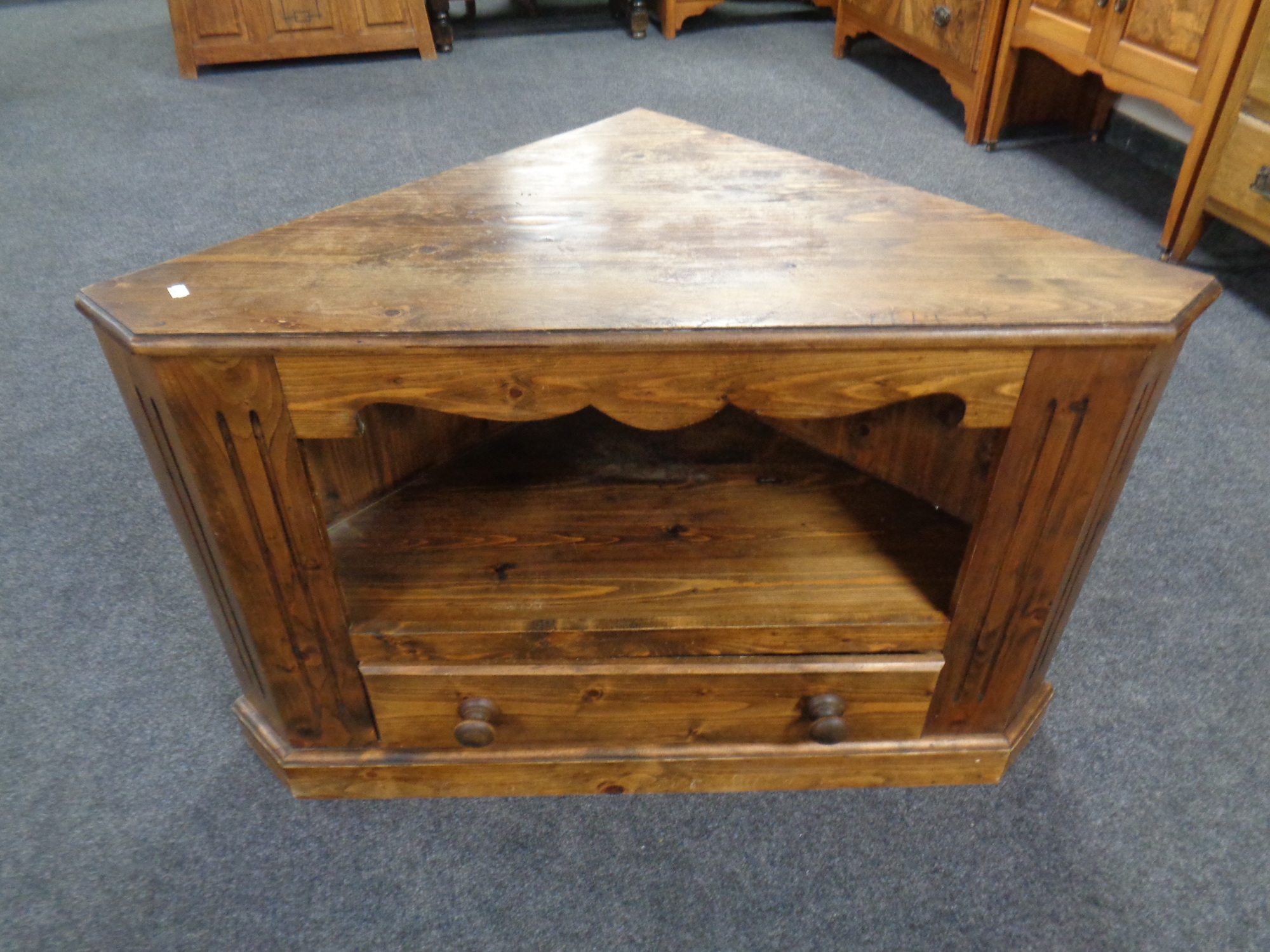 A stained pine corner entertainment unit fitted a drawer