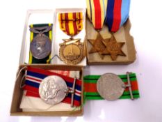 Four WWII war medals on ribbons to include the 1939-45 Star, The Africa Star,