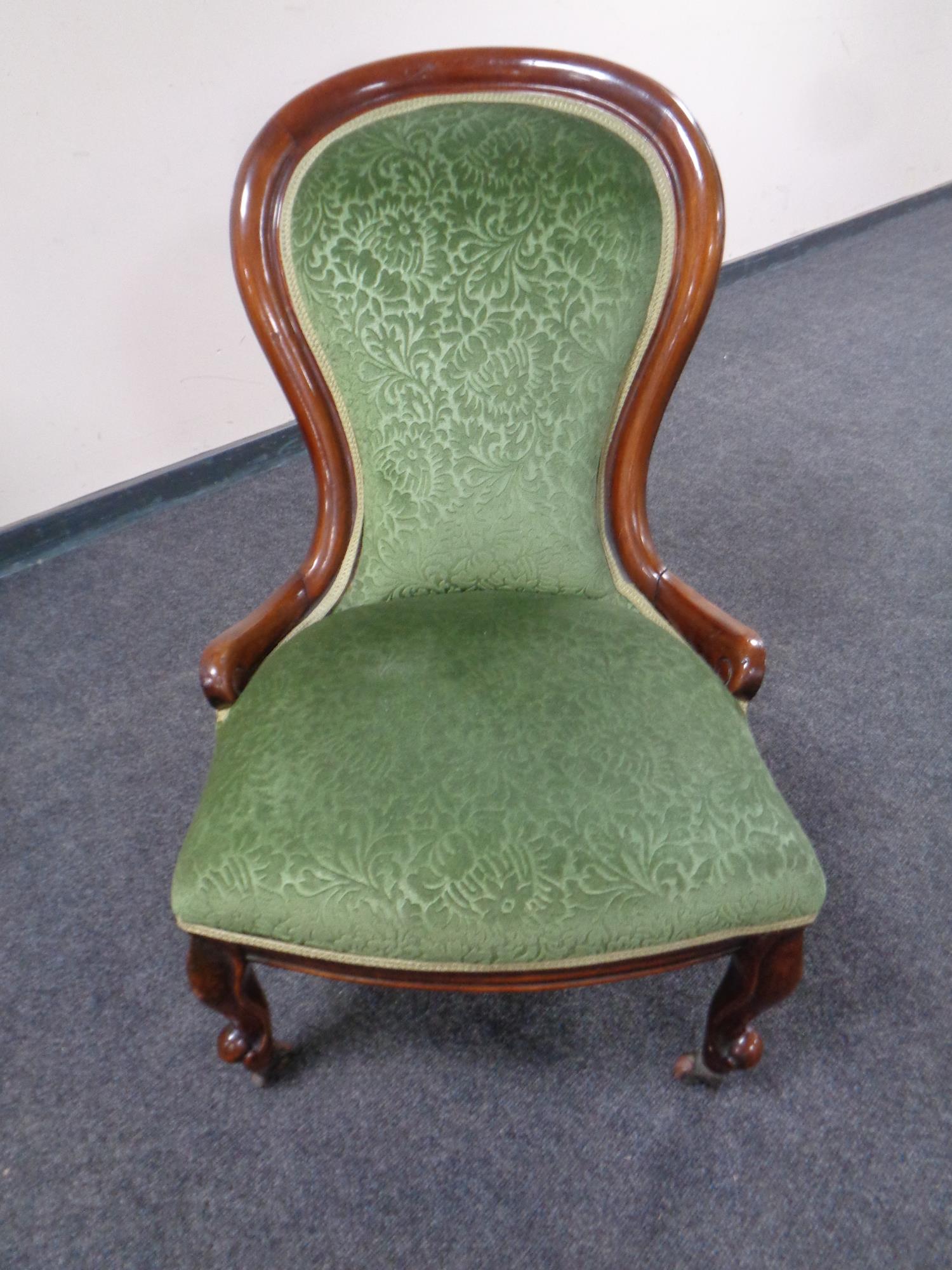 A Victorian mahogany nursing chair in green upholstery