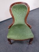 A Victorian mahogany nursing chair in green upholstery