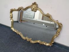 A period style overmantel mirror in swept gilt frame