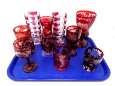 A tray containing six Bohemian cranberry glassware to include vases, beakers,