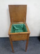 An Edwardian oak sewing box on raised legs