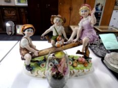 A large Capodimonte ceramic figure group of children on a wooden see-saw together with an orchid in
