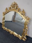 A period style overmantel mirror in swept gilt frame