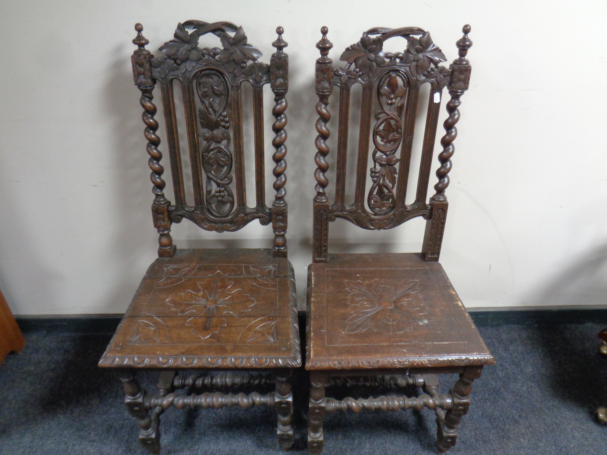 A pair of heavily carved oak hall chairs