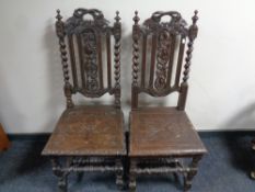 A pair of heavily carved oak hall chairs