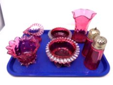 A tray containing seven pieces of antique cranberry glassware to include salt and pepper pots, vase,