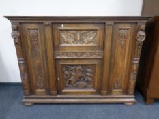 A 20th century continental carved oak and beech secretaire sideboard