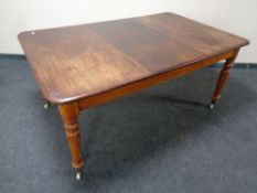 A Victorian mahogany rectangular dining table on ceramic casters together with a set of four chairs