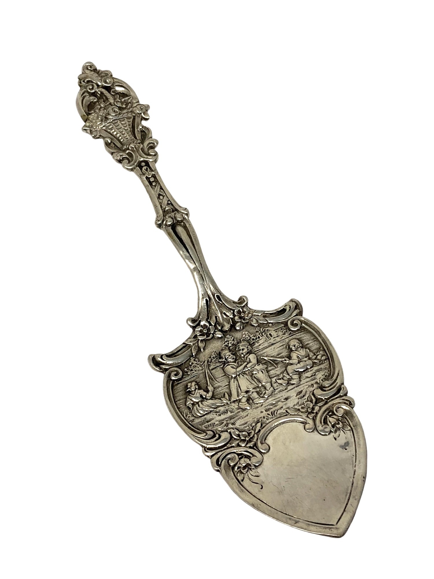 An ornate silver cake slice,