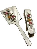 A two piece floral enamel and silver mirror and brush set