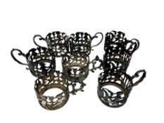 A set of eight ornate Victorian silver cup holders decorated with putti