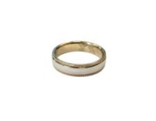 A 9ct white gold band ring with yellow gold millgrain edge, size K/L, 3.8g.