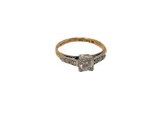 An antique 18ct gold diamond solitaire ring with diamond set shoulders,