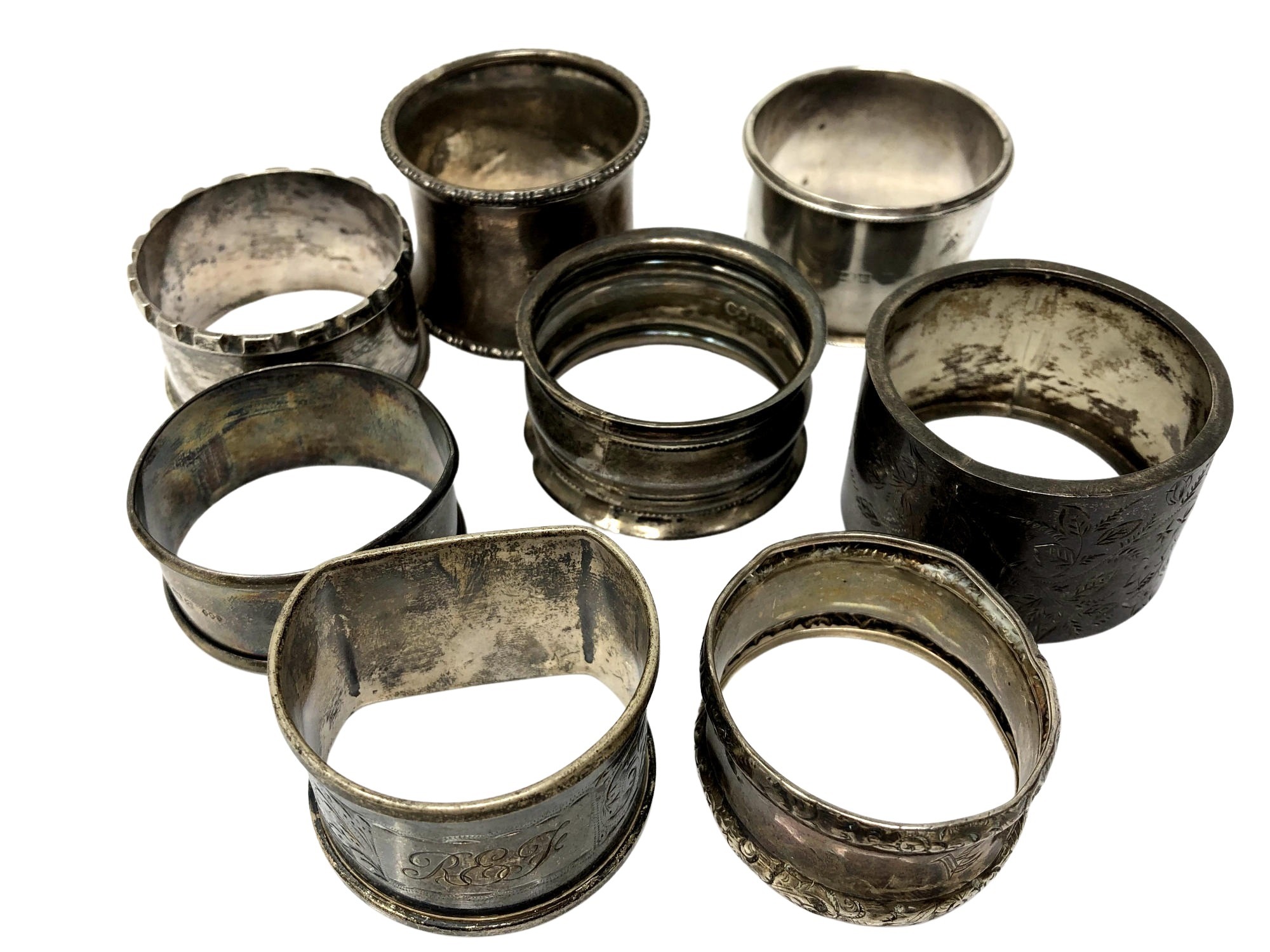 Eight assorted silver serviette rings.