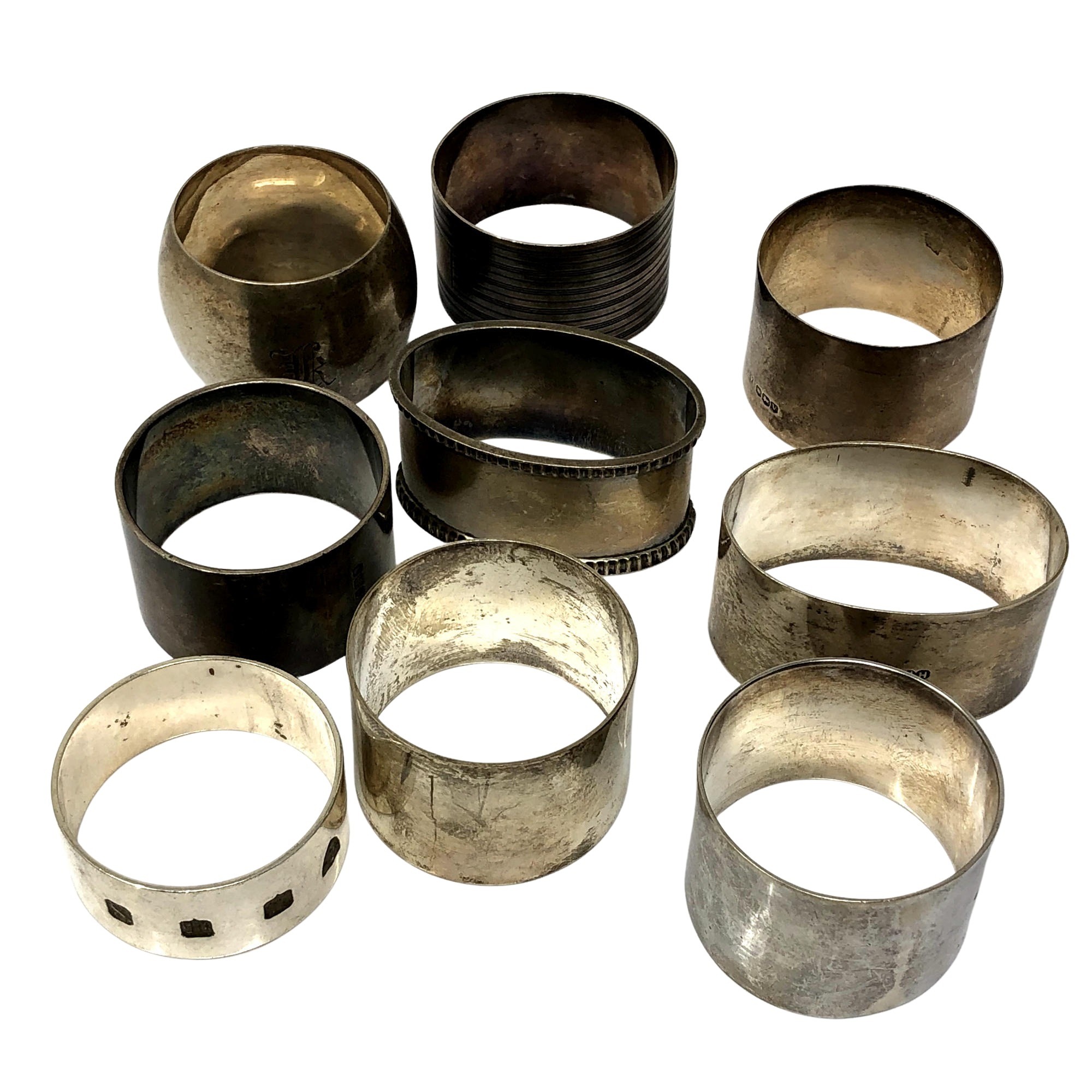 Nine heavy gauge silver serviette rings, 307g.