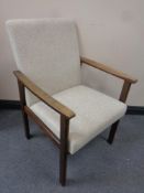 A beech framed armchair in beige fabric