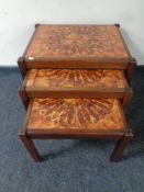 A nest three 20th century teak tiled topped tables
