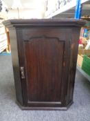 A Georgian oak panel door hanging corner cabinet