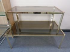 Two graduated brass framed coffee tables with smoked glass tops