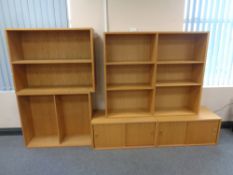 Two sliding door low cupboards in an oak finish and three sets of open bookshelves
