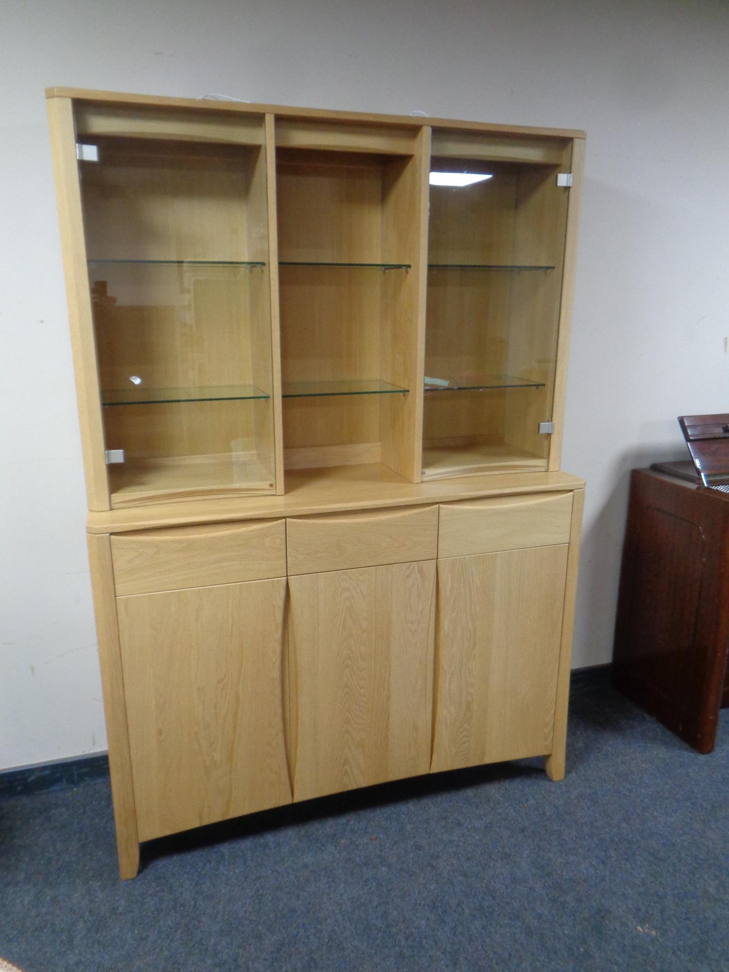 An Ercol Artisan display cabinet fitted with three door three drawer sideboard beneath