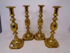 A set of four 19th century Queen of Diamonds brass candlesticks