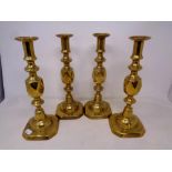 A set of four 19th century Queen of Diamonds brass candlesticks