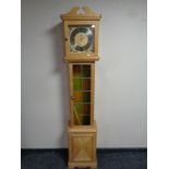 A continental blond oak cased longcase clock with leaded panel door