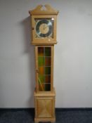 A continental blond oak cased longcase clock with leaded panel door