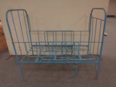 An antique wrought iron extending cot bed