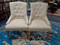 A pair of contemporary high back lady's chairs in beige button fabric