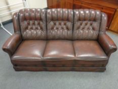 A late 20th century continental brown leather button back three seater settee