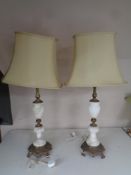 A pair of ornate brass and alabaster table lamps with shades