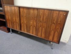 A mid 20th century rosewood triple sliding door sideboard on raised legs, height 95 cm,